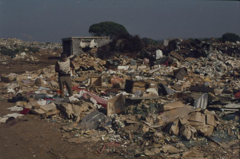 Pored bora u betonskim blokovima pod plažom kućica; u I. planu čovjek prebire po smeću; Gradski deponij