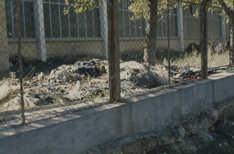 Krpe trikotaže pored zida unutar tvorničkog kruga na hrpama pored puta - prilaz rijeci